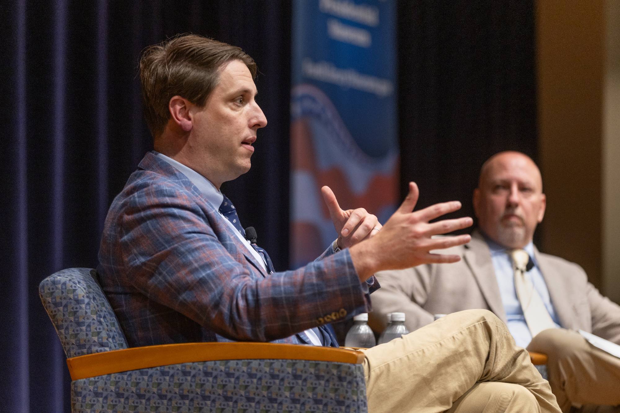 Guest speaker Garrett Graff speaks from the stage while guest moderator Joel Westphal looks on.